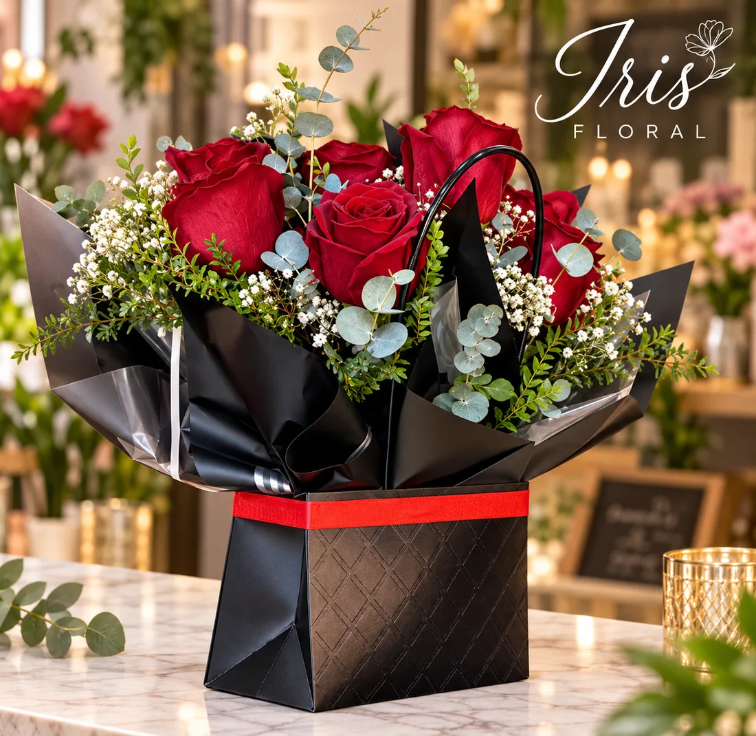 Ramo de rosas rojas con flores blancas y eucalipto en envoltura negra